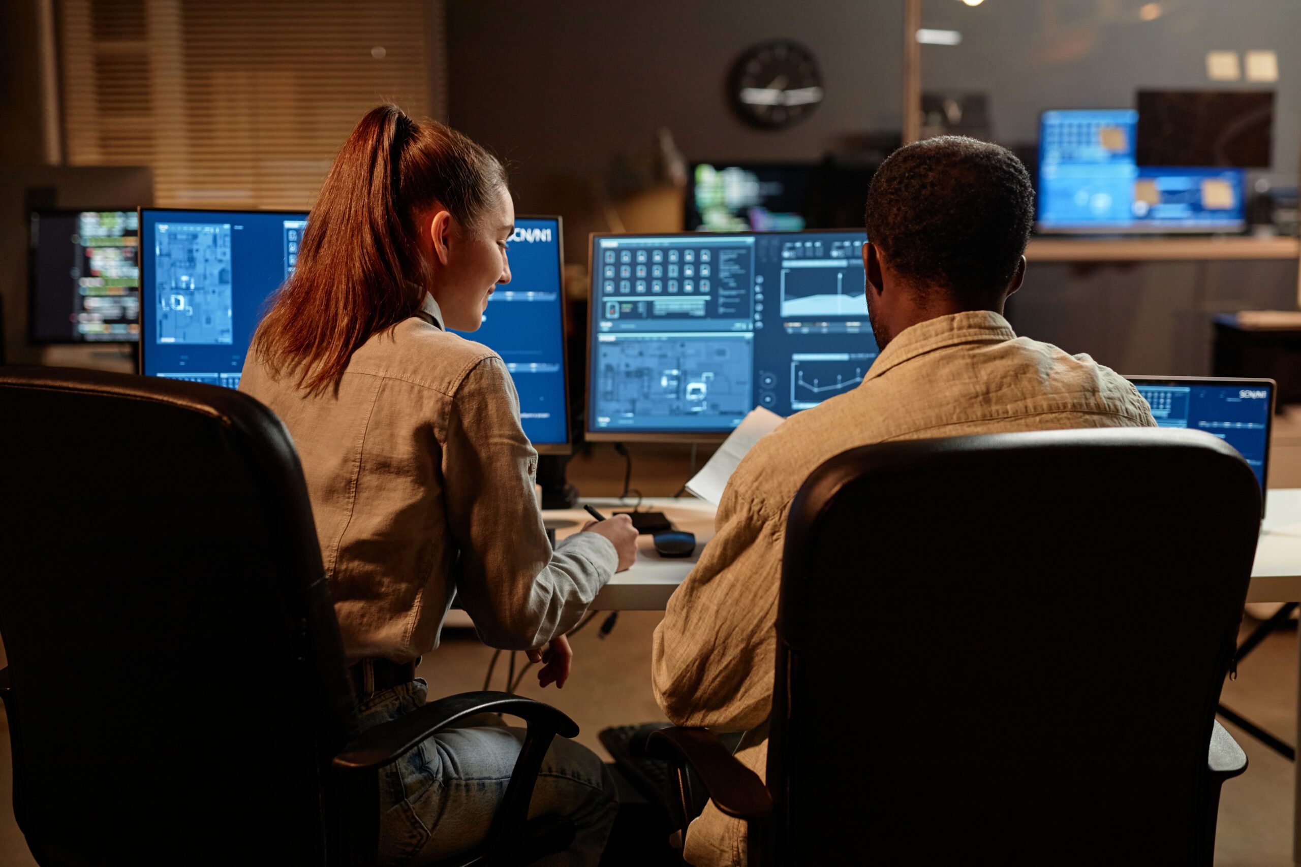 Security analysts monitoring data on multiple screens