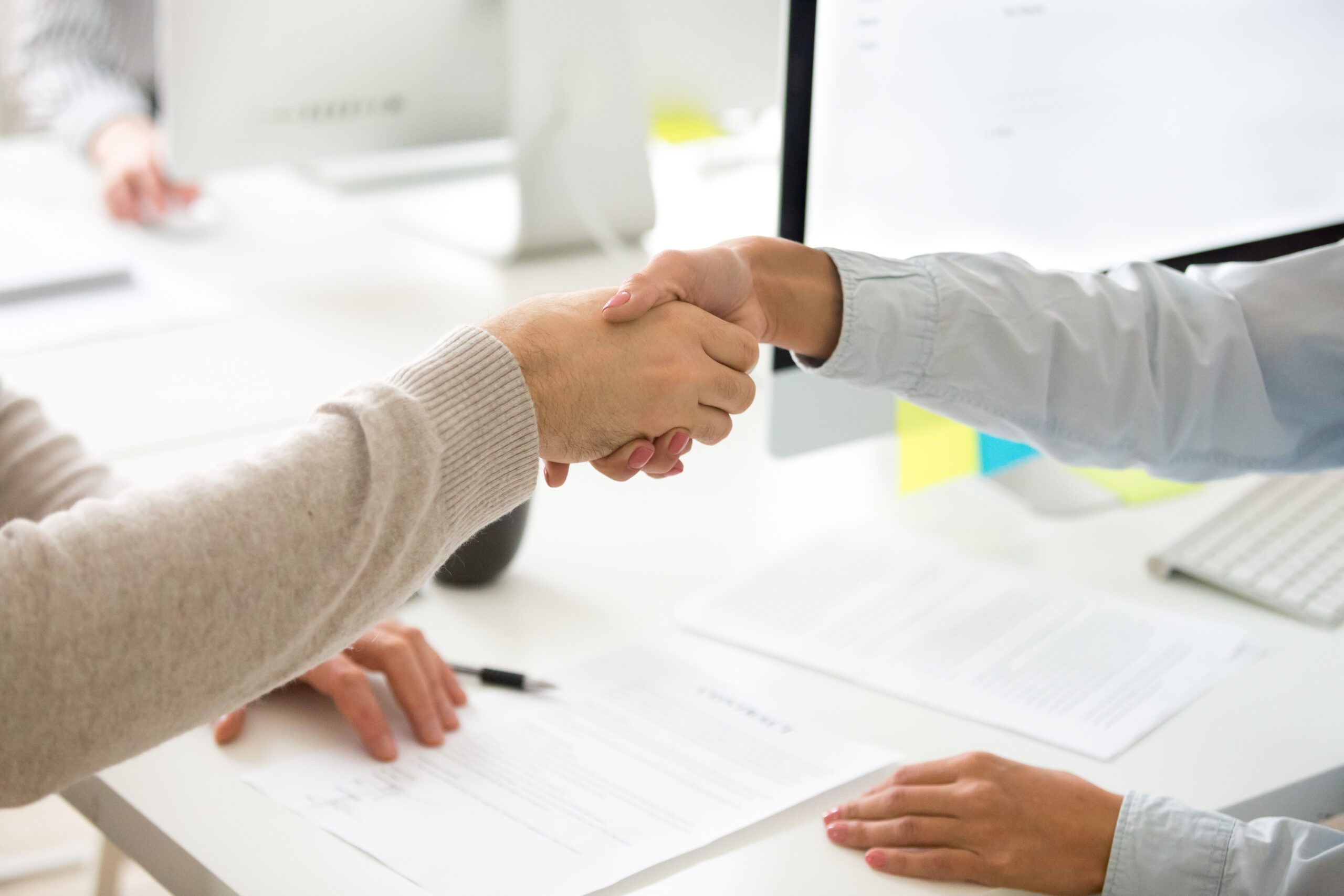 Man and woman shaking hands after signing a business contract